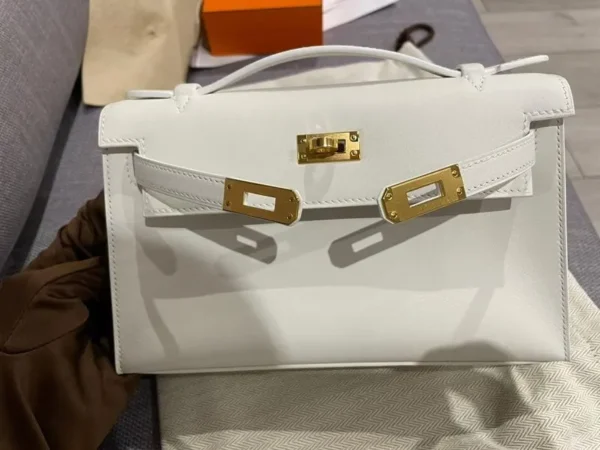 حقيبة هيرميس Kelly Pochette من جلد سويفت باللون الأبيض مع إكسسوارات معدنية ذهبية